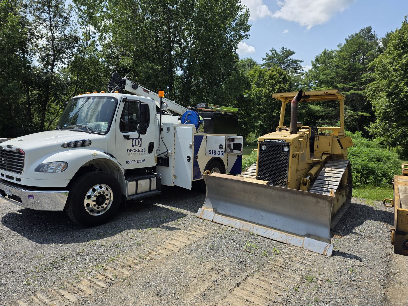 Decker's Industrial service truck alongside a Caterpillar dozer on a gravel site during a service call