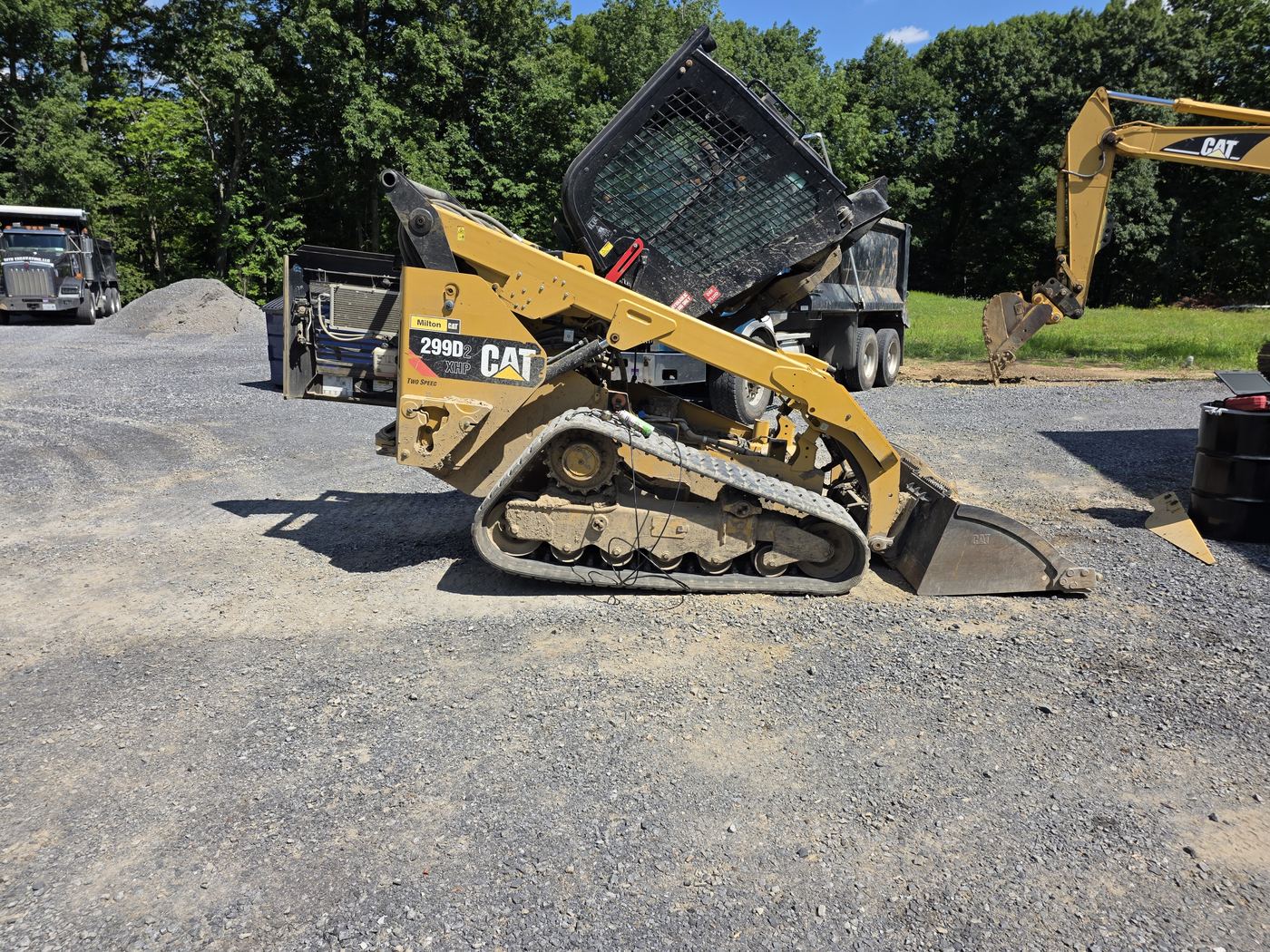 CAT 299D compact track loader with the rear hood raised beside the Decker's Industrial service truck