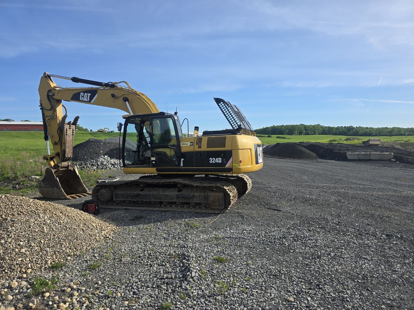 CAT 324D excavator parked on a gravel pad after field service in the Capital Region